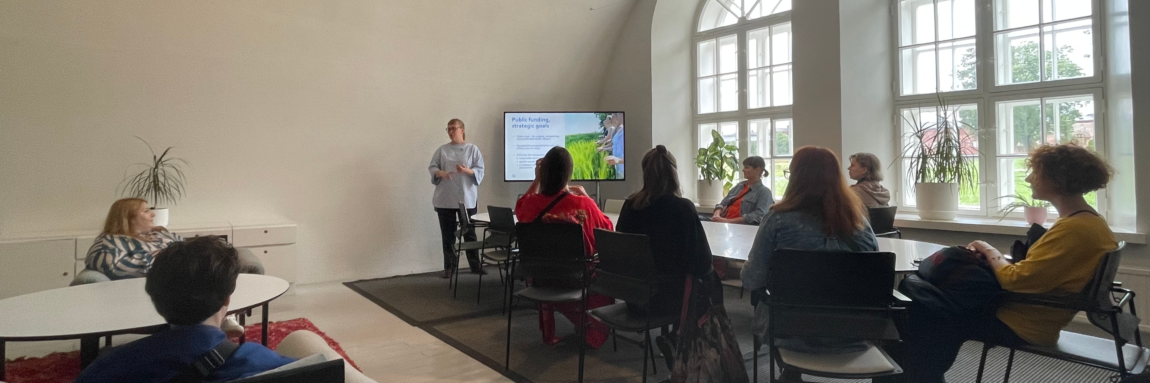 Katja Långvik presenterar de nordiska stödprogrammen för en grupp besökare. 