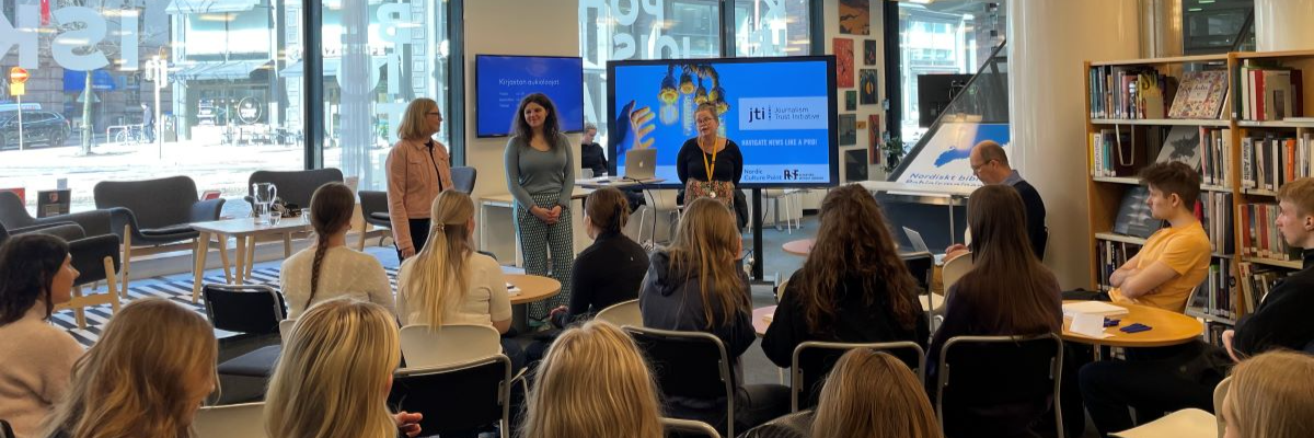 Tre kvinnor står framför en ung publik i Nordisk kulturkontakts bibliotek.