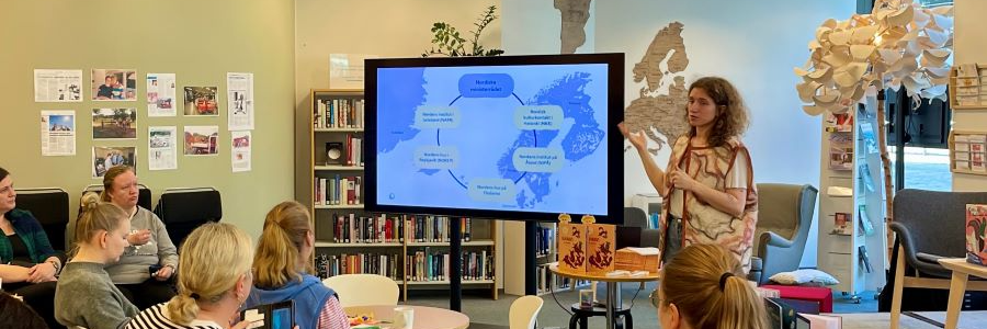 En grupp kvinnor lyssnar på en presentation i ett bibliotek