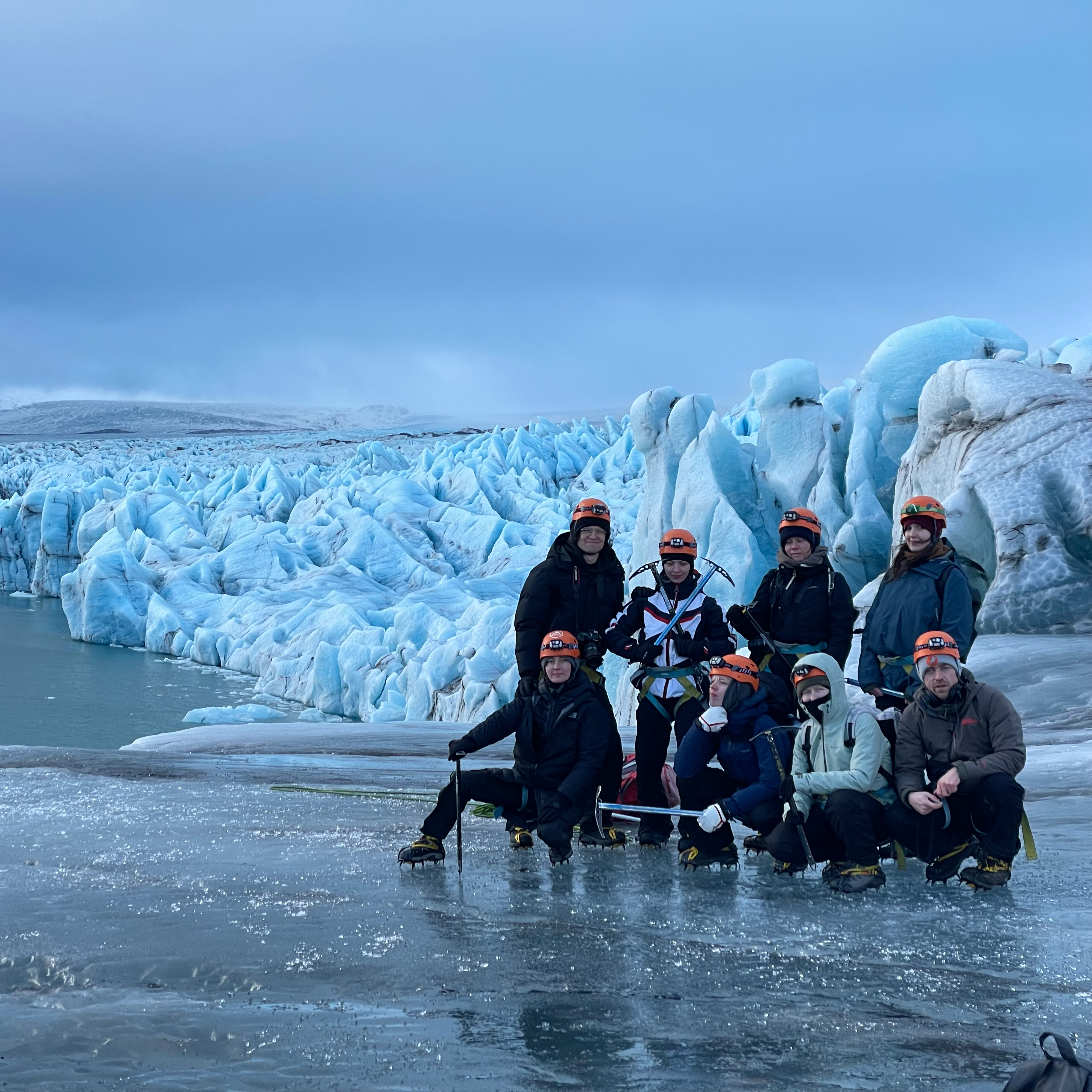A group of people standing in front of an ice berg